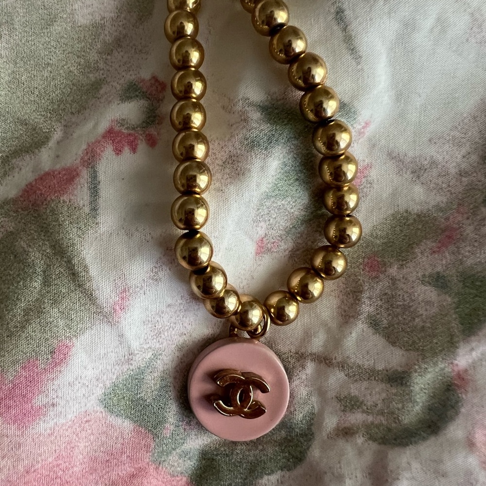 Gold filled necklace with pink emblem